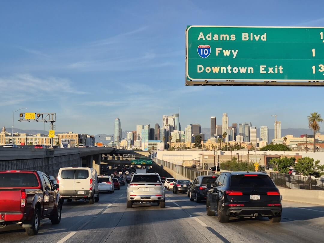 A highway filled with lots of traffic next to tall buildings
