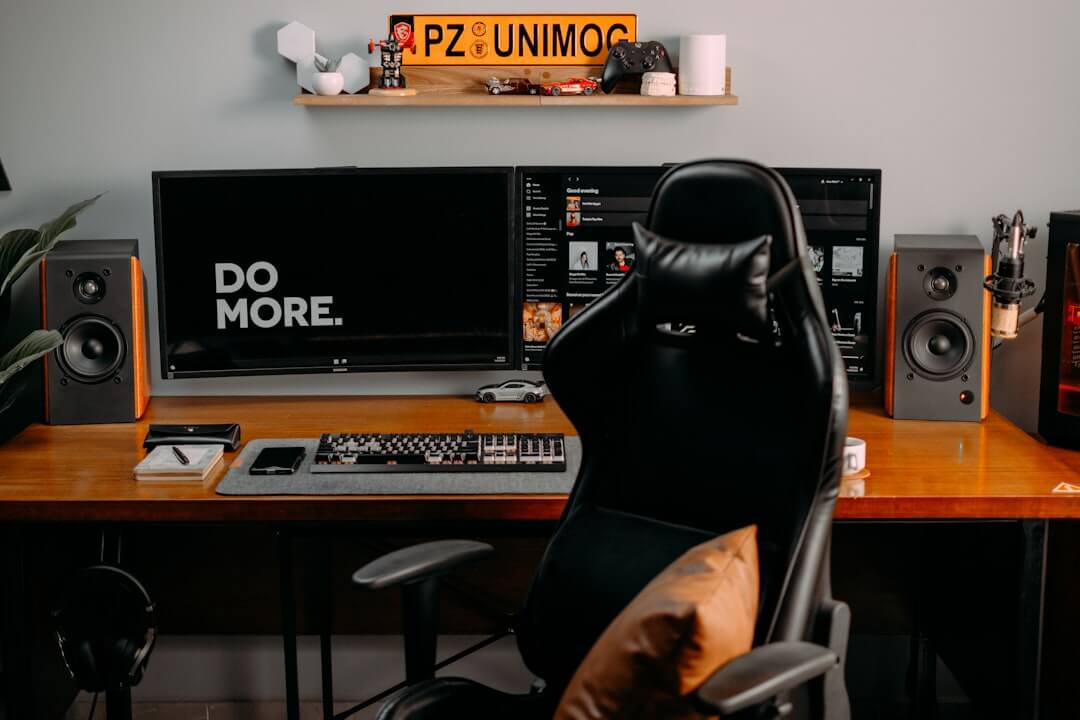 a person sitting at a desk with a computer and speakers