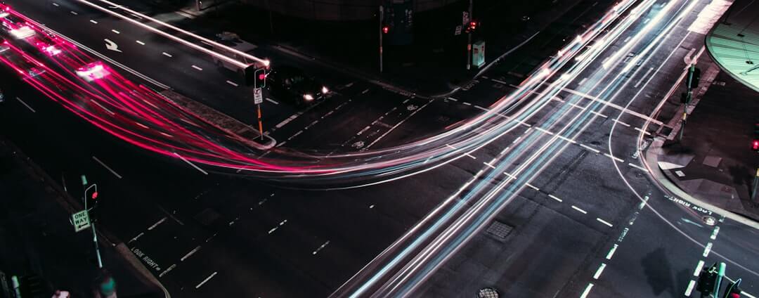 red and white car lights streaking at street corner
