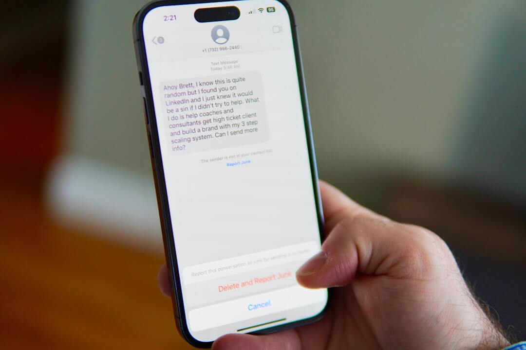 Hand holding a smartphone displaying a text message conversation.