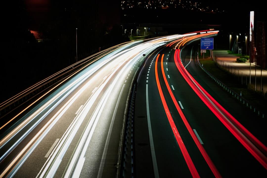 a long exposure photo of a highway at night