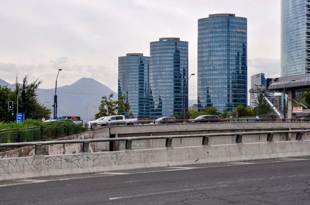 Modern skyscrapers and traffic on a highway with mountains.