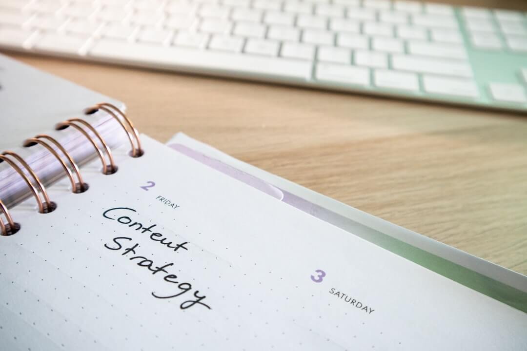 a notepad with a spiral - bound notebook on it next to a keyboard