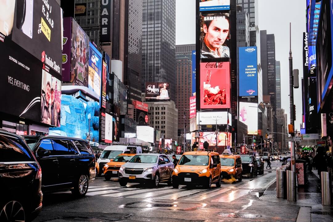 Busy times square with traffic and bright signs.