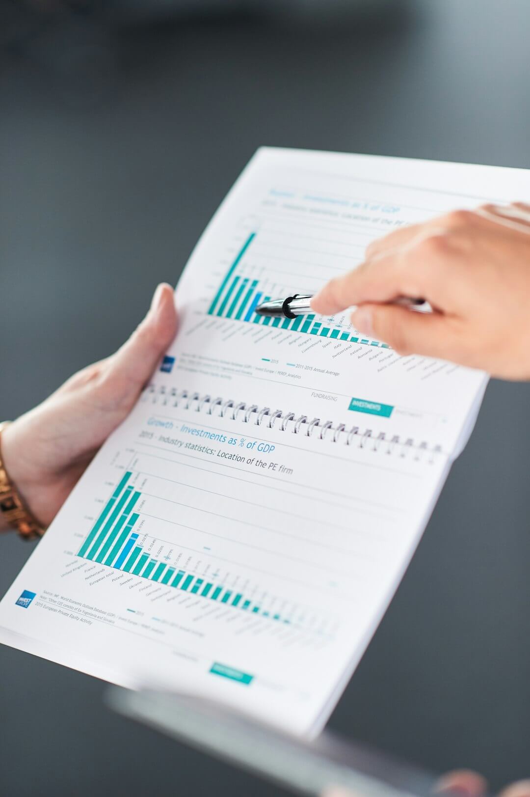 Hands pointing at data charts in a document