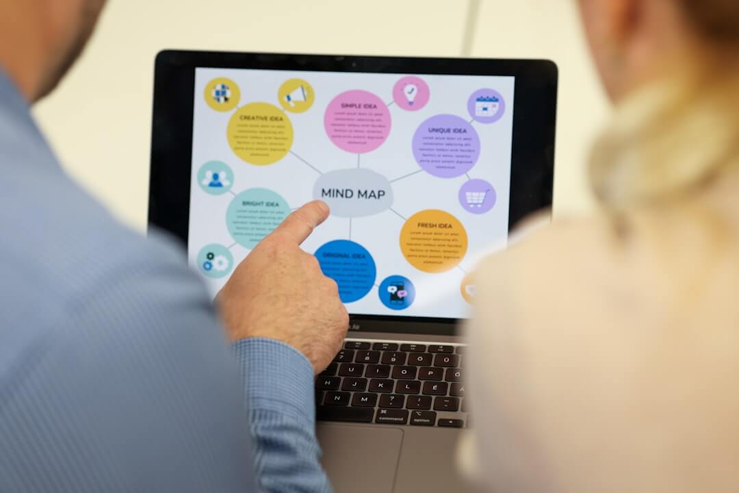 People are looking at a mind map on a laptop screen