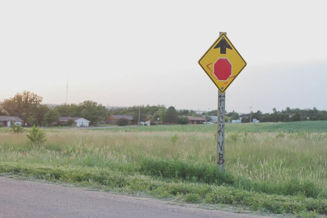 a yellow and red sign sitting on the side of a road