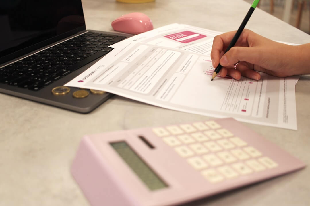 Someone is working on paperwork with a calculator