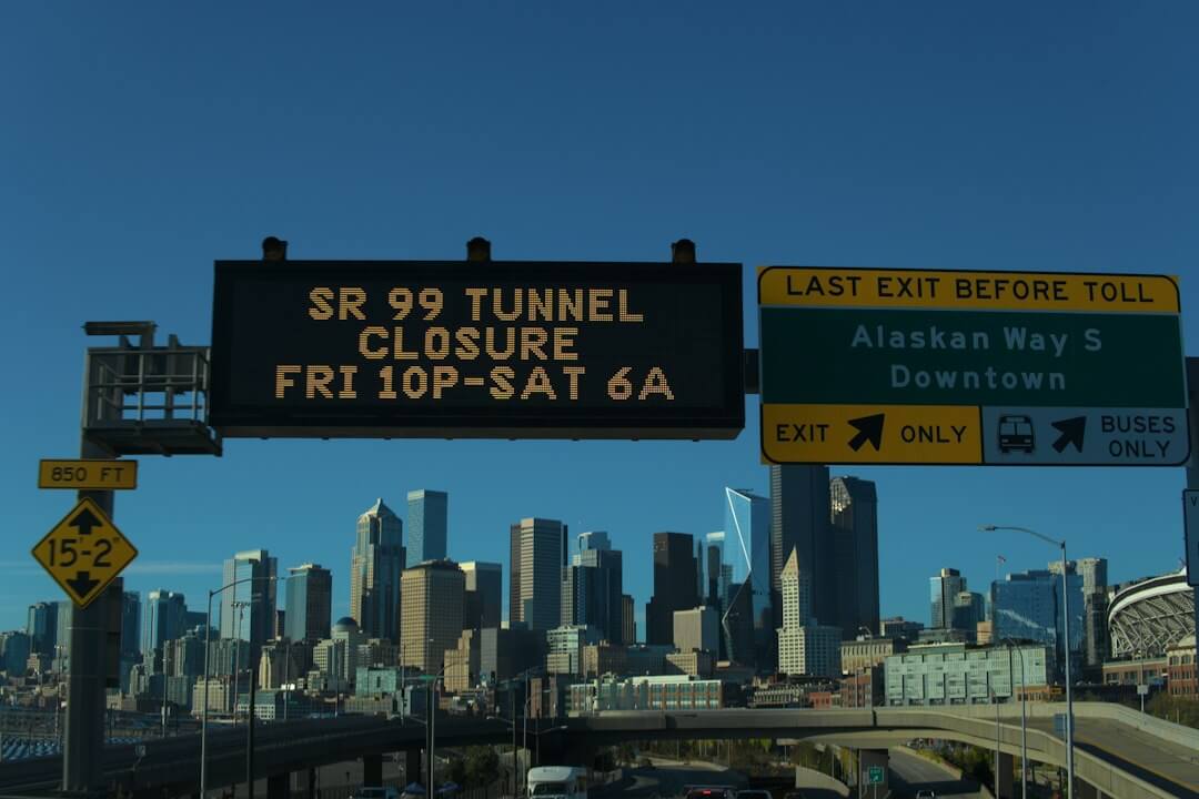 A digital highway sign displaying SR 99 tunnel closure information before the Seattle skyline