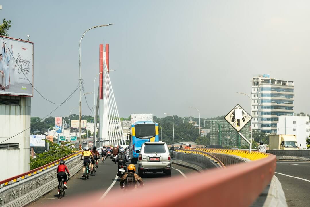 Cars, cyclists, and buses travel on a bridge