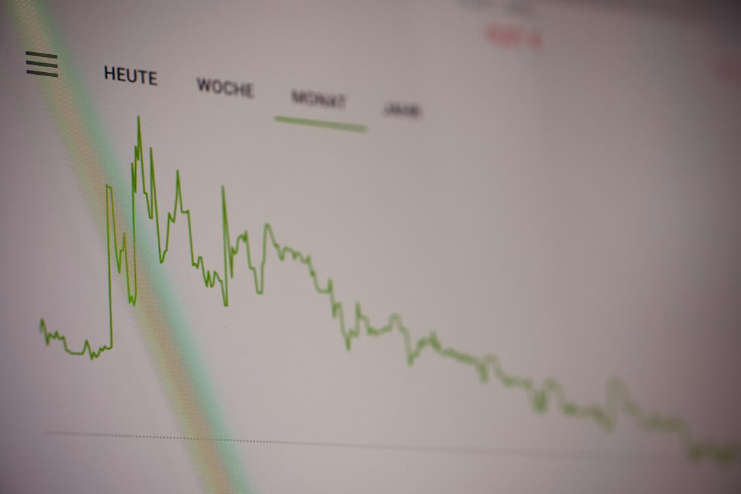 A green line graph showing stock market trends on a digital screen