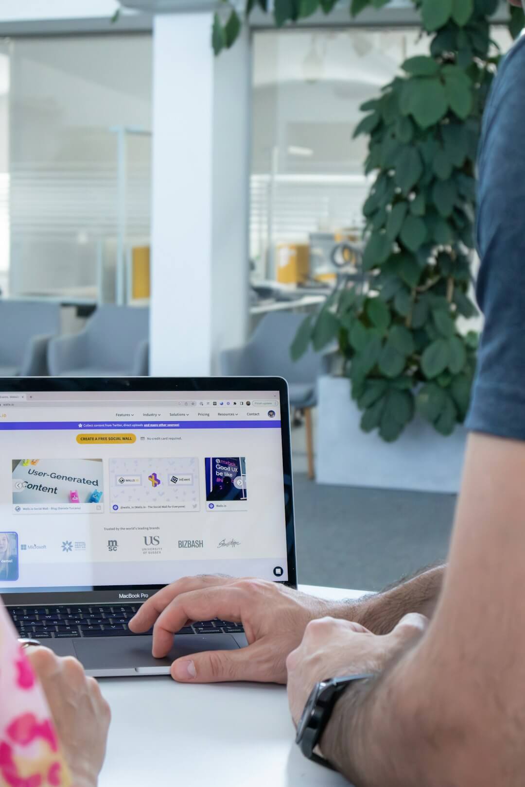 a man and a woman sitting at a table with a laptop