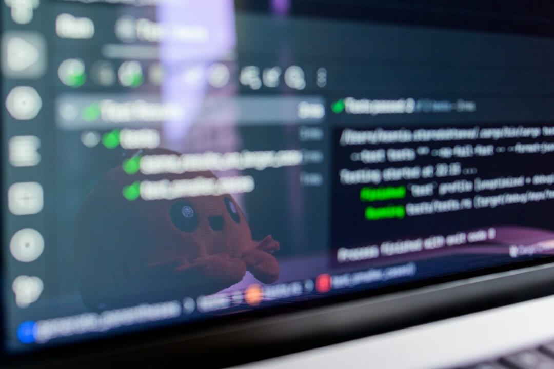 Computer screen displaying code with a toy reflected